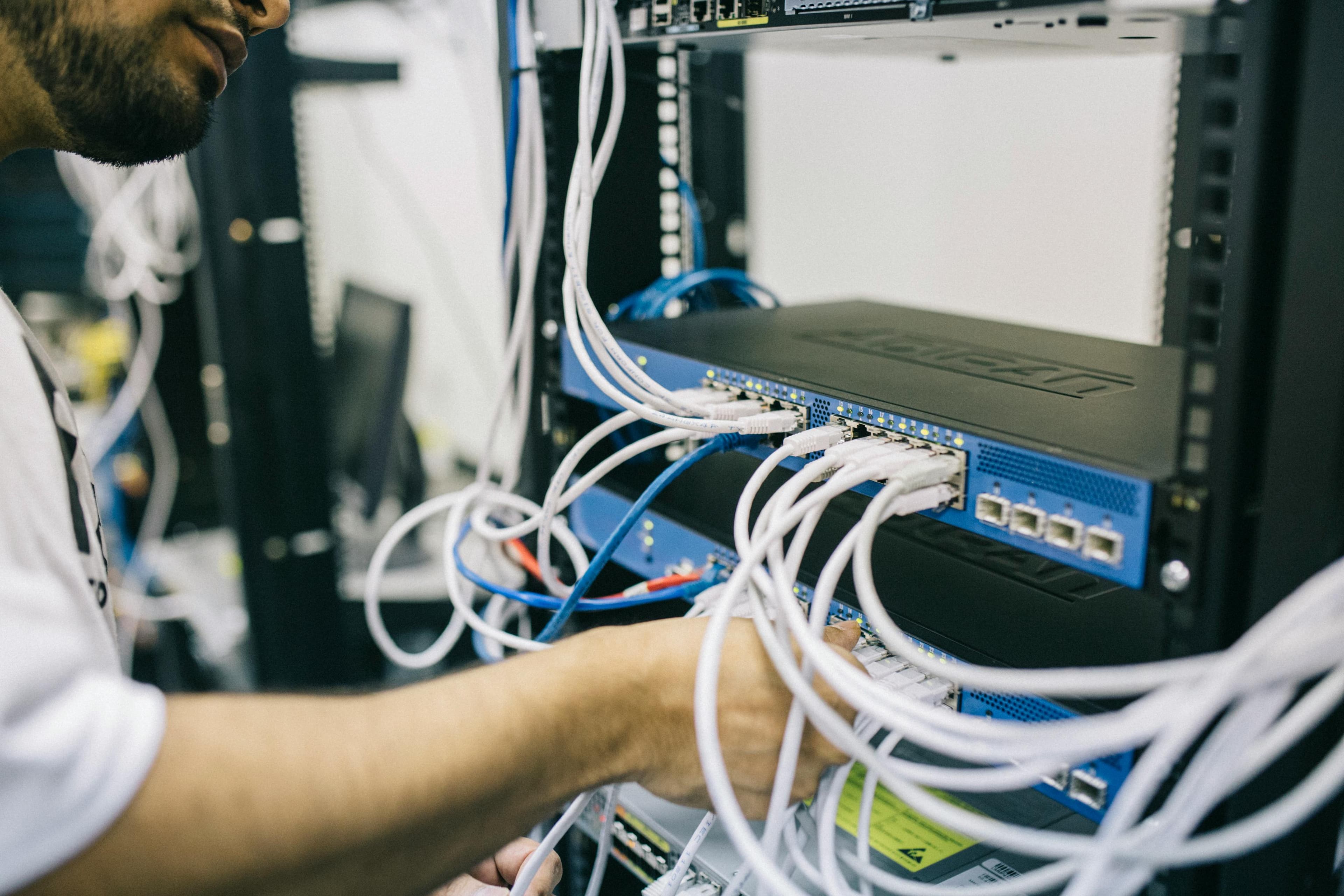 Technicien travaillant sur un rack réseau et câblage